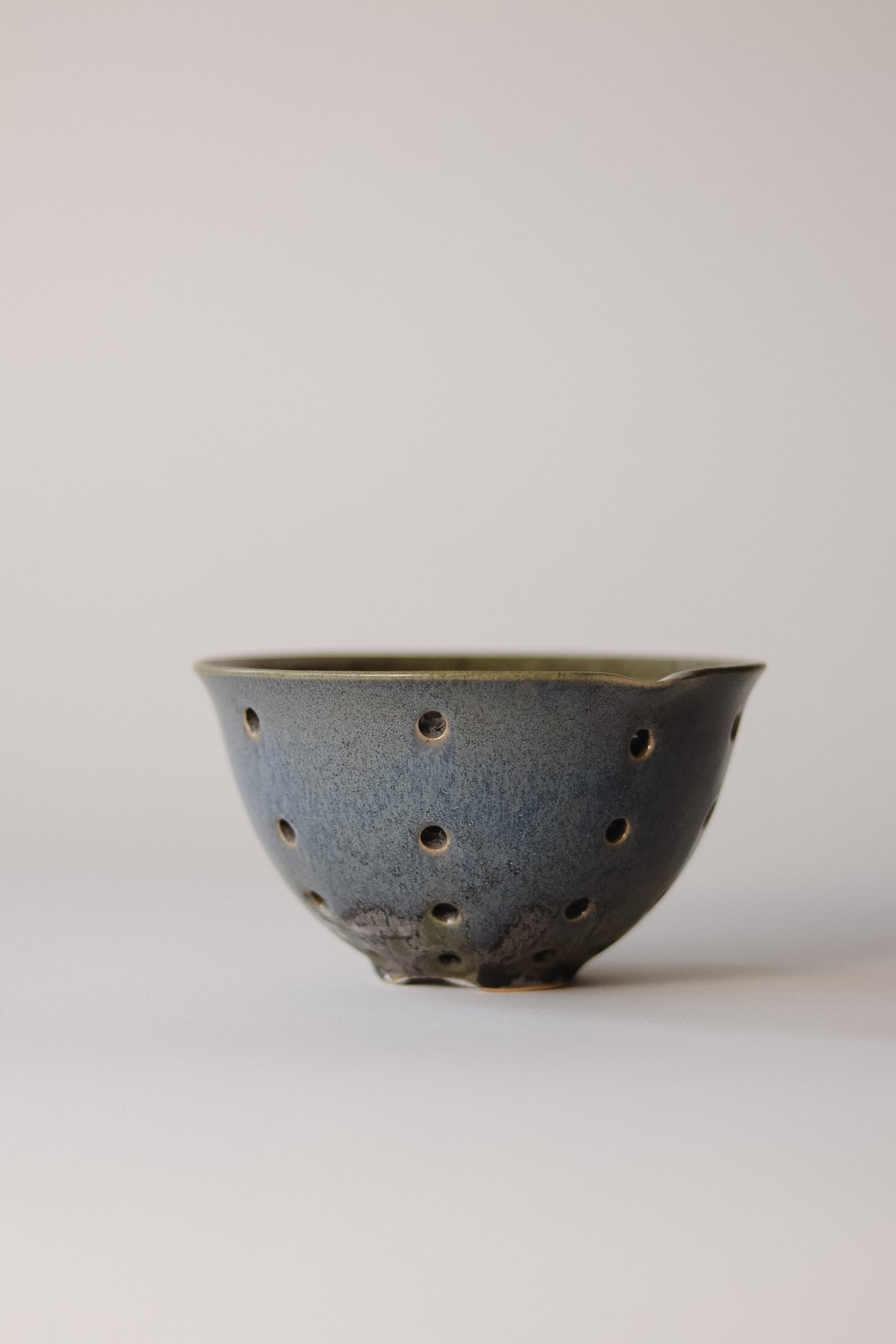 A handcrafted stoneware bowl with a speckled glaze, perfect for displaying seasonal berries.